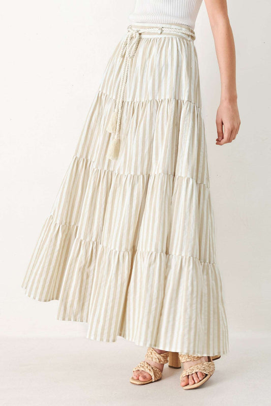 Tiered cream and tan striped fabric maxi skirt with a rope belt and tassel detail.