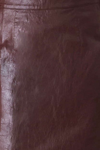 A close-up of a dark brown leather surface with visible texture, grain, and a seam line near the top.