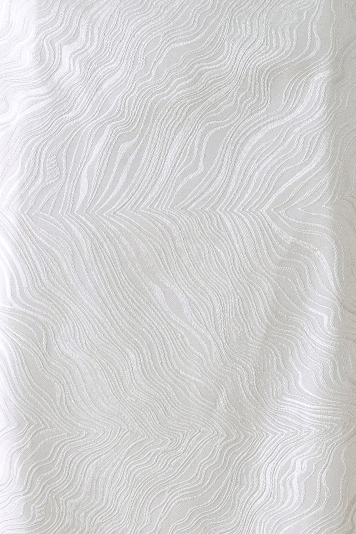 White textured fabric with a raised wavy, topographic pattern.