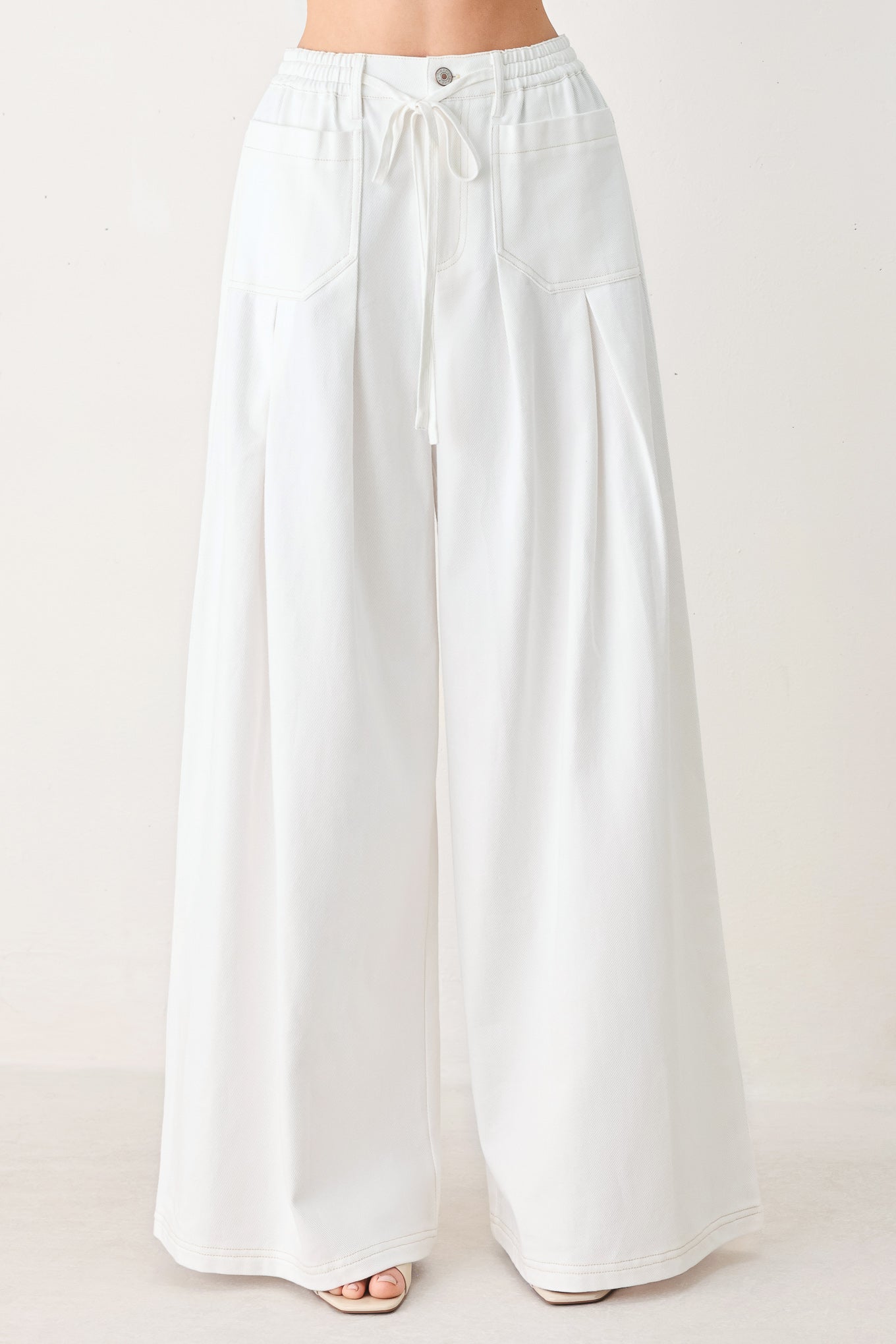White wide-leg pants on a plain background