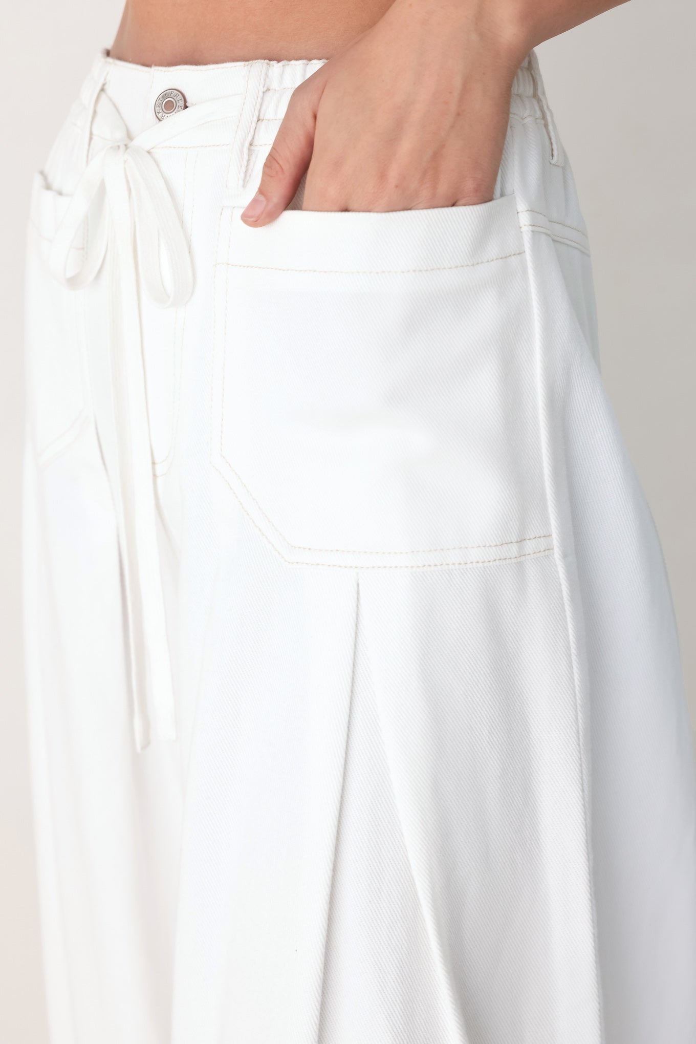 White pants with a tie waist on a plain background