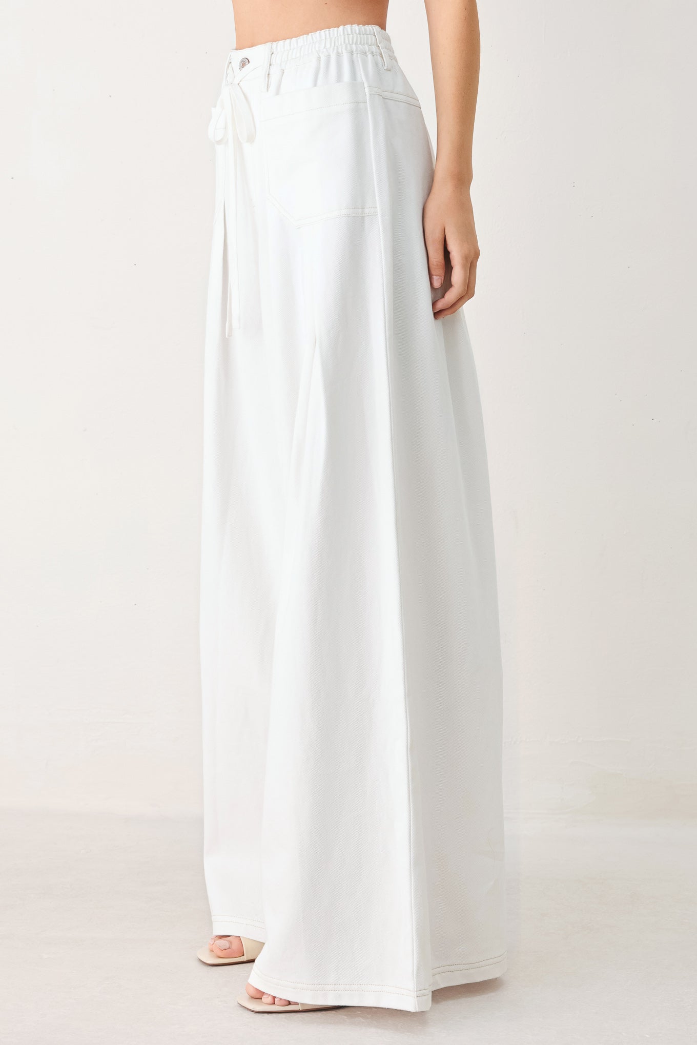 White wide-leg pants worn by a person on a white background