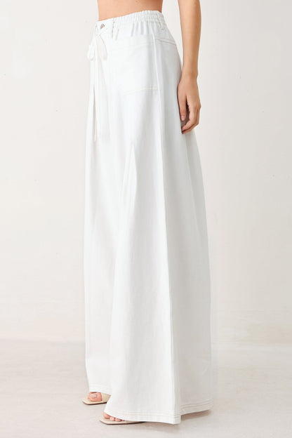 White wide-leg pants worn by a person on a white background