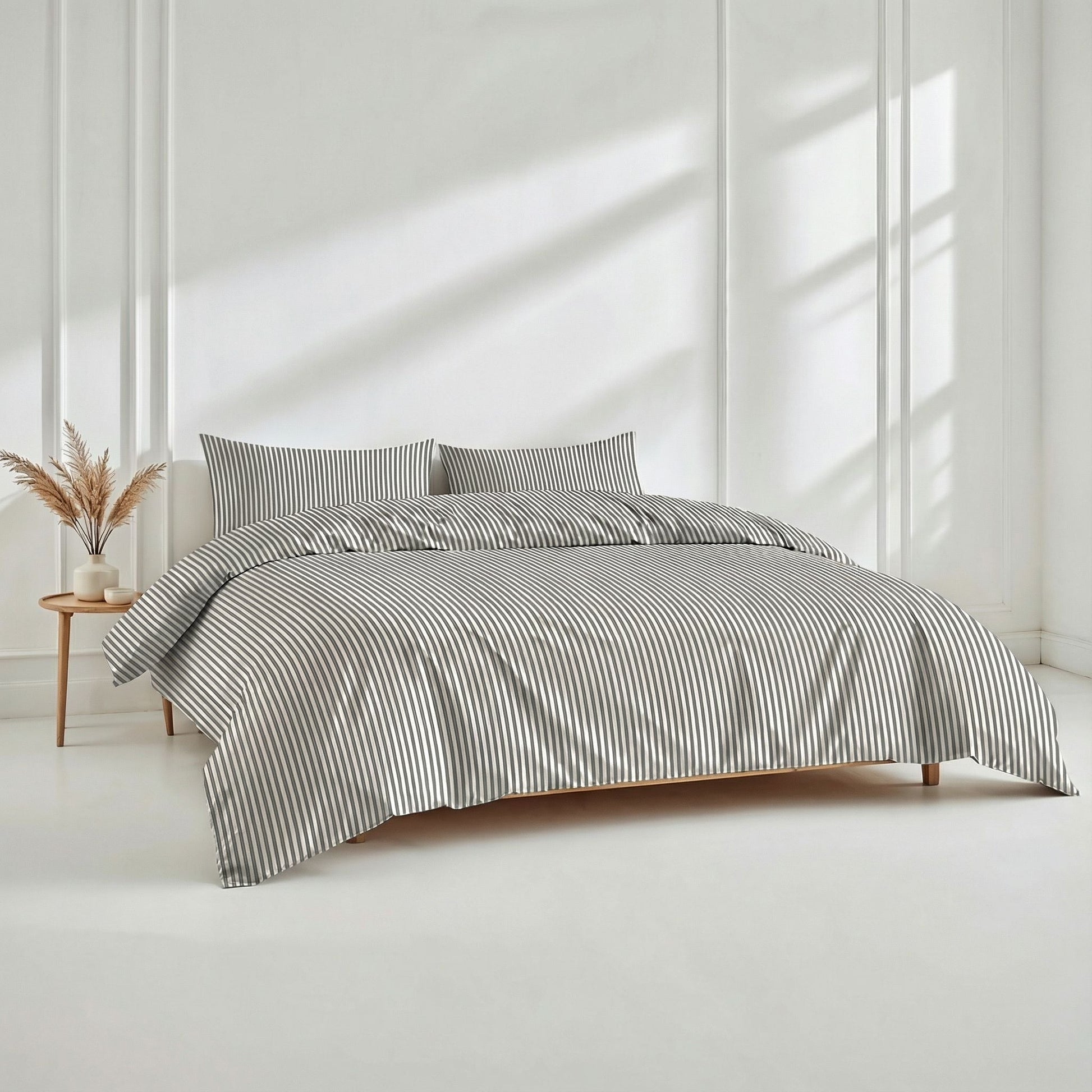 Bed with striped bedding in a bright room with sunlight filtering through.