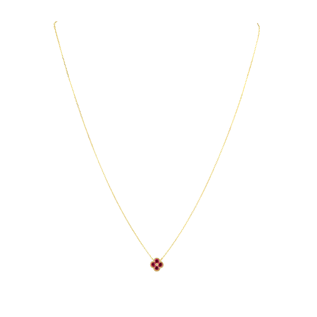 Gold necklace with a red gemstone pendant on a white background
