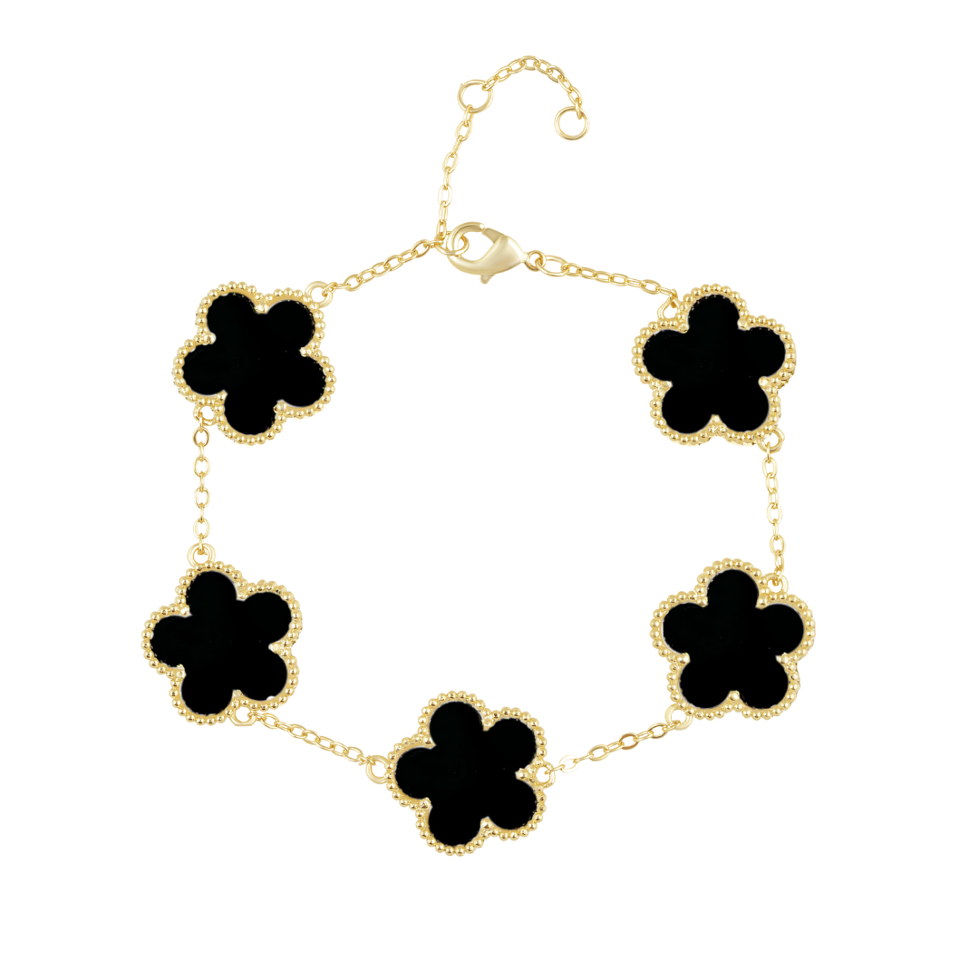 Gold bracelet with black clover-shaped charms on a white background