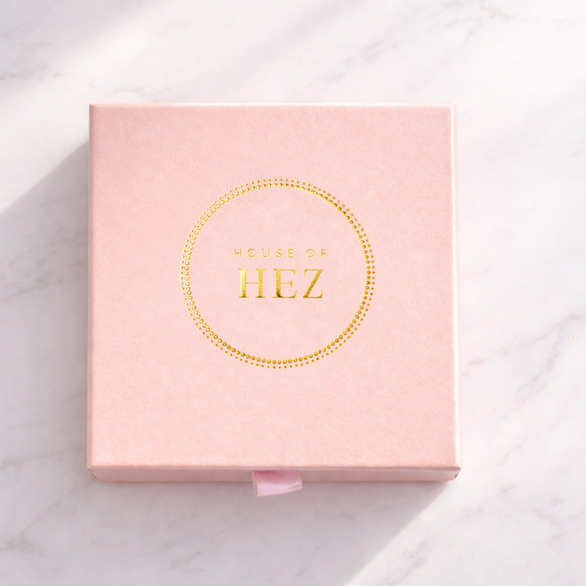 Pink box with 'House of HEZ' branding on a light background