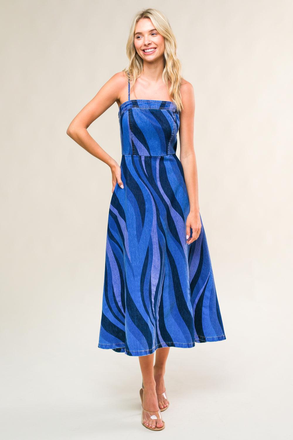 Woman wearing a blue zebra print dress against a plain background