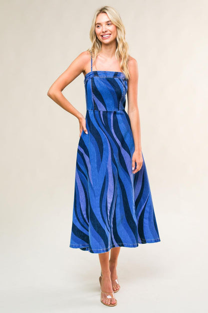 Woman wearing a blue zebra print dress against a plain background
