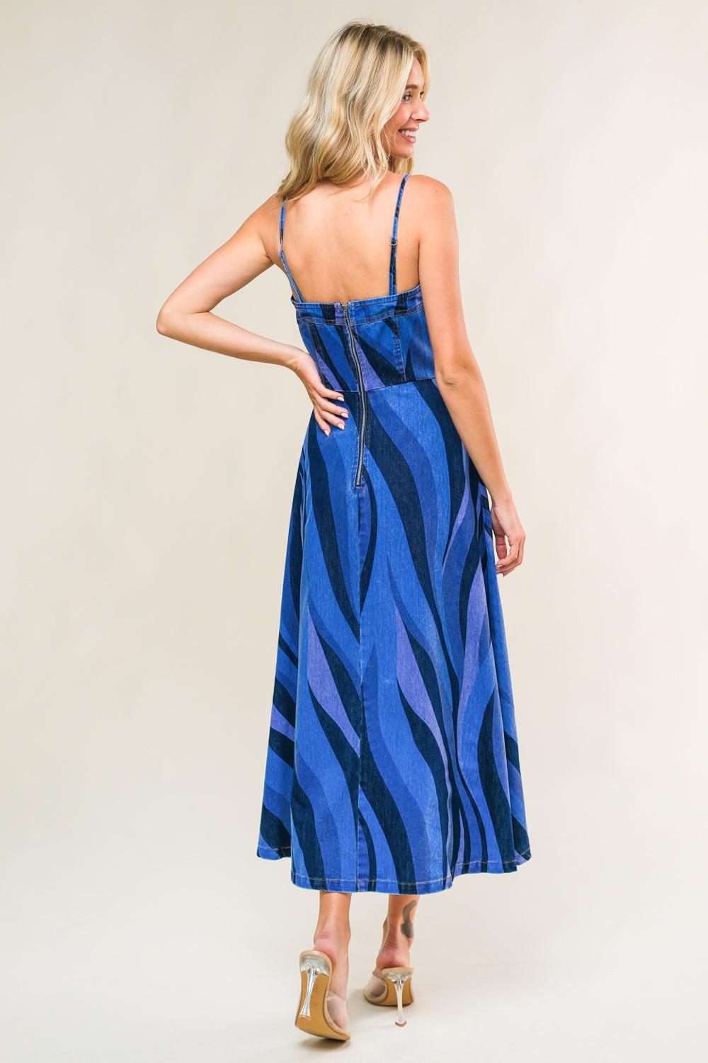 Woman wearing a blue and black patterned dress against a plain background