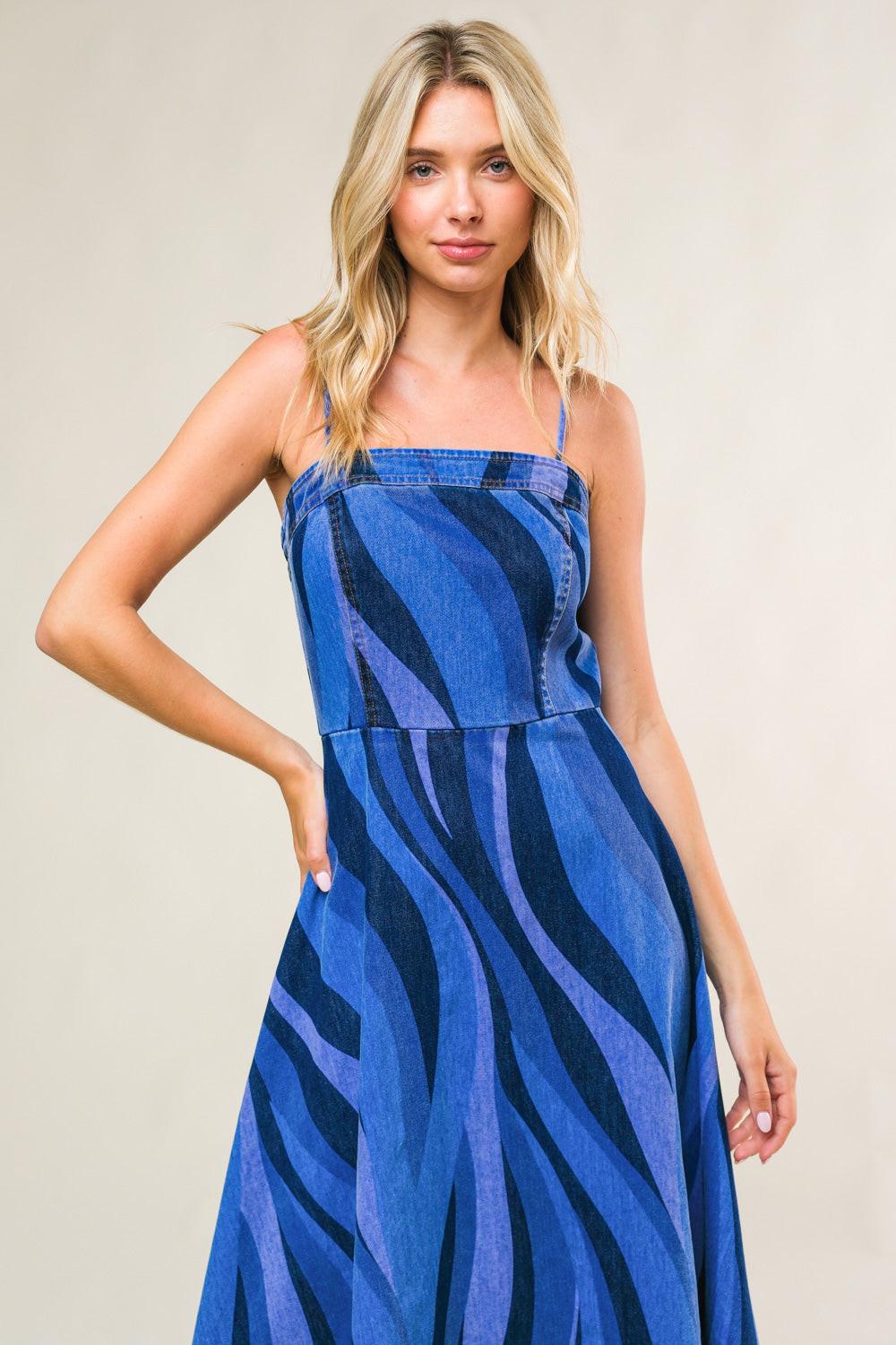 Woman wearing a blue patterned dress against a plain background