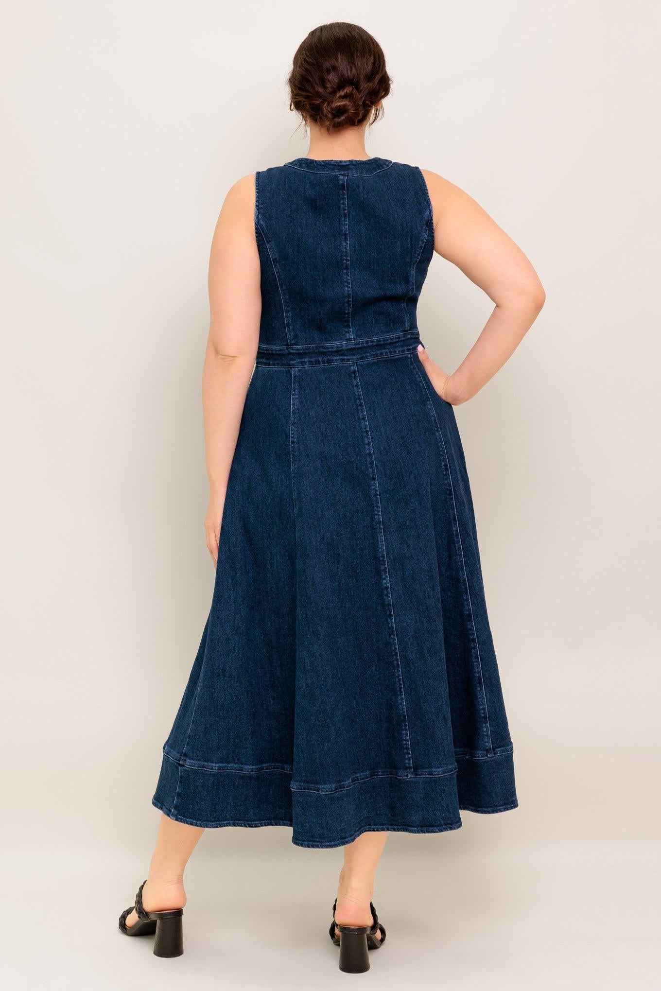 Woman wearing a blue denim dress against a plain background
