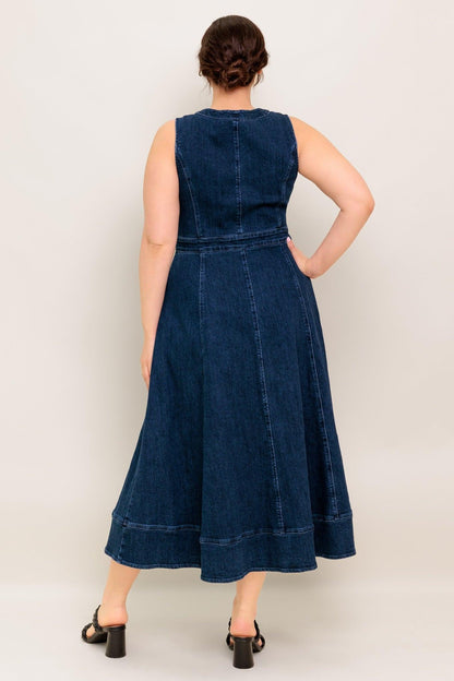 Woman wearing a blue denim dress against a plain background
