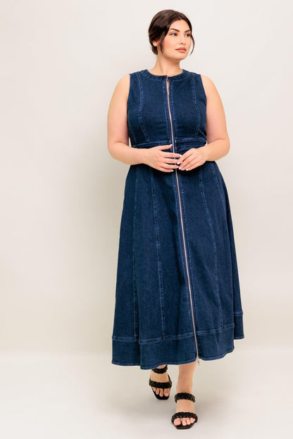 Woman wearing a blue denim dress against a white background