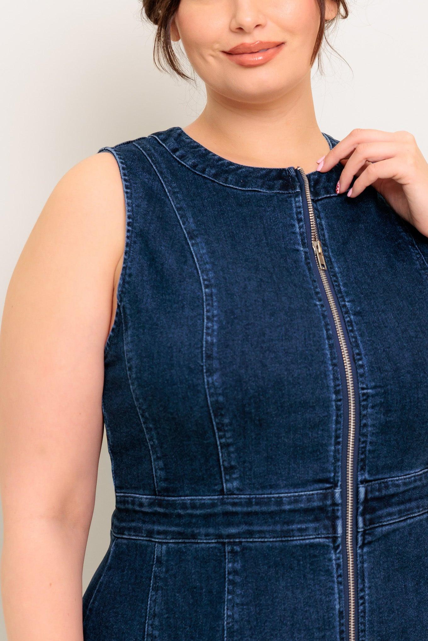 Woman wearing a blue denim dress against a plain background