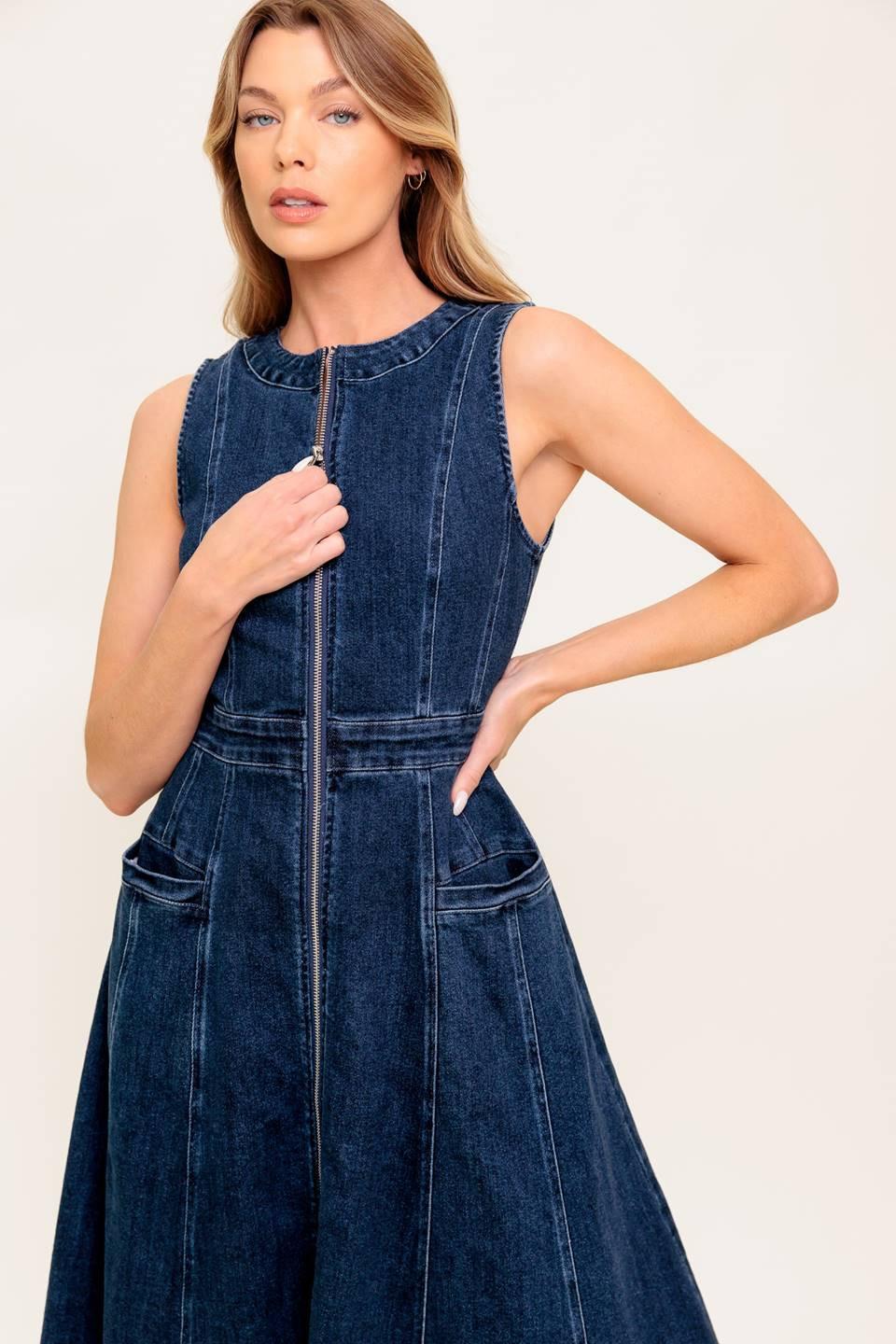 Woman wearing a blue denim dress against a white background