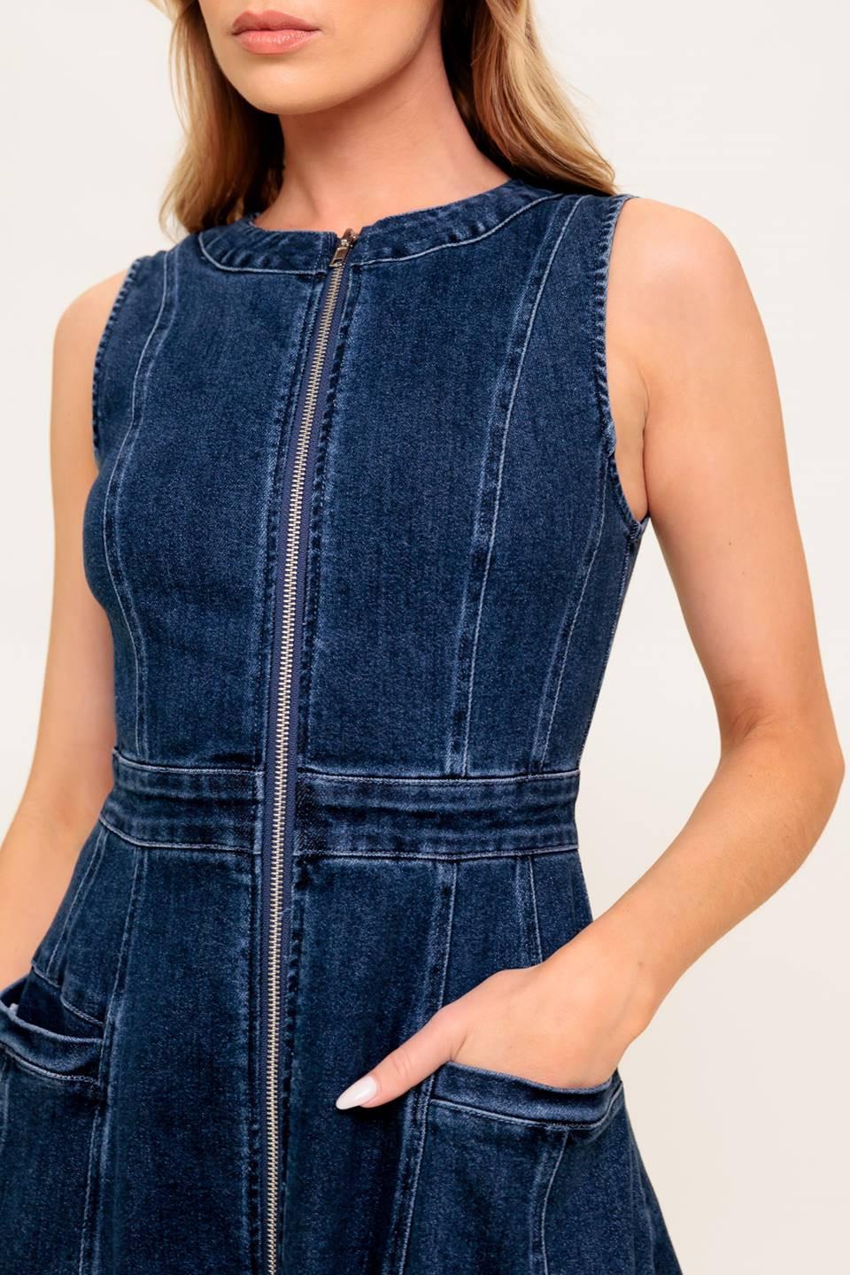 Blue denim dress worn by a person on a white background
