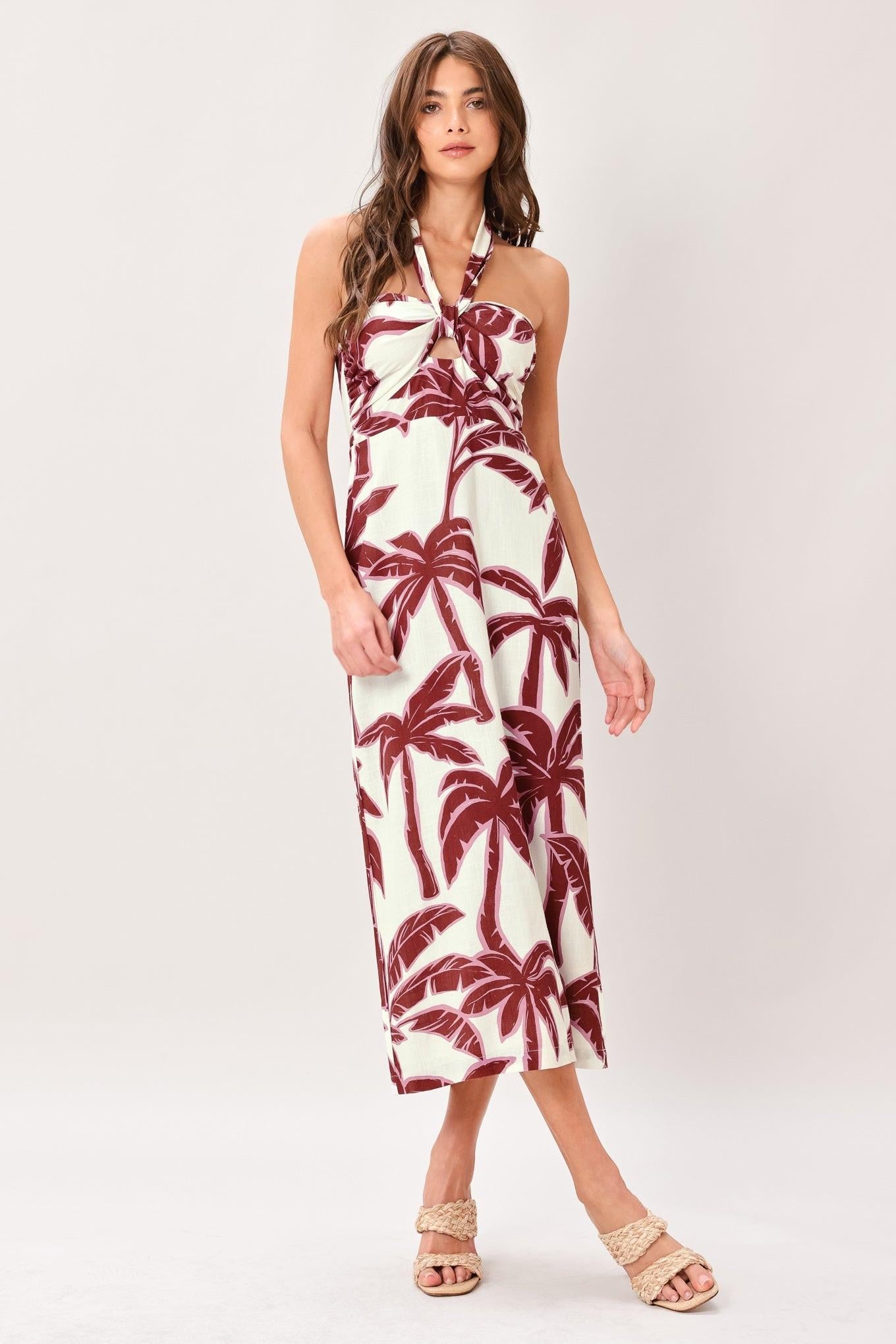 Woman wearing a white dress with red palm tree pattern on a white background