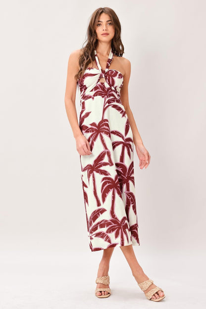 Woman wearing a white dress with red palm tree pattern on a white background