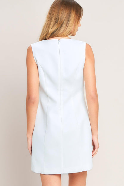 White sleeveless dress worn by a person on a beige background