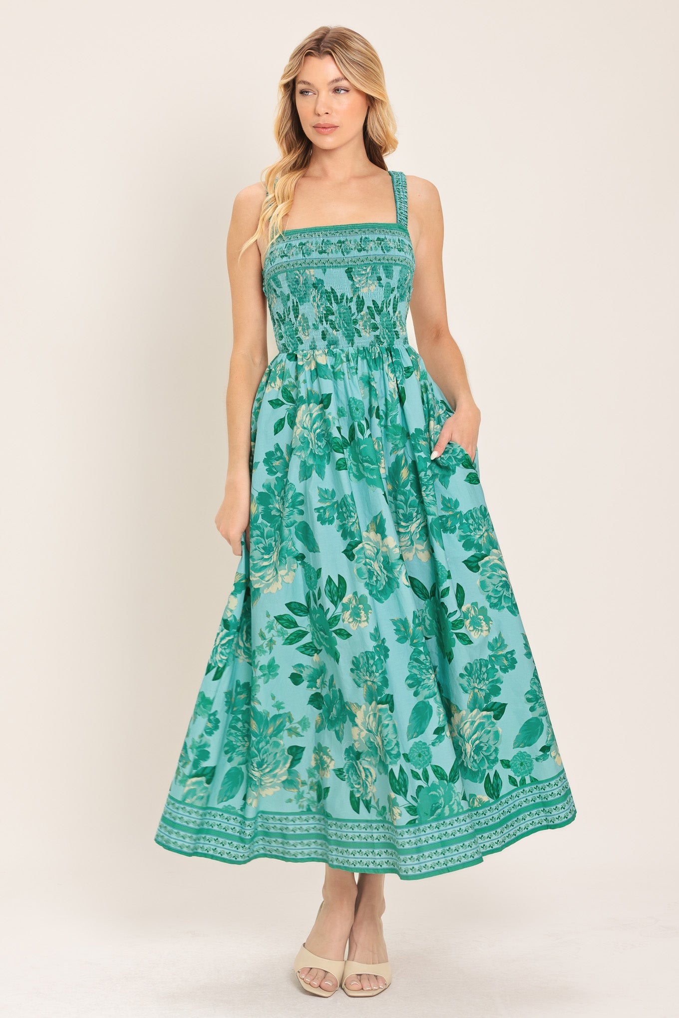 Woman wearing a green floral dress on a white background
