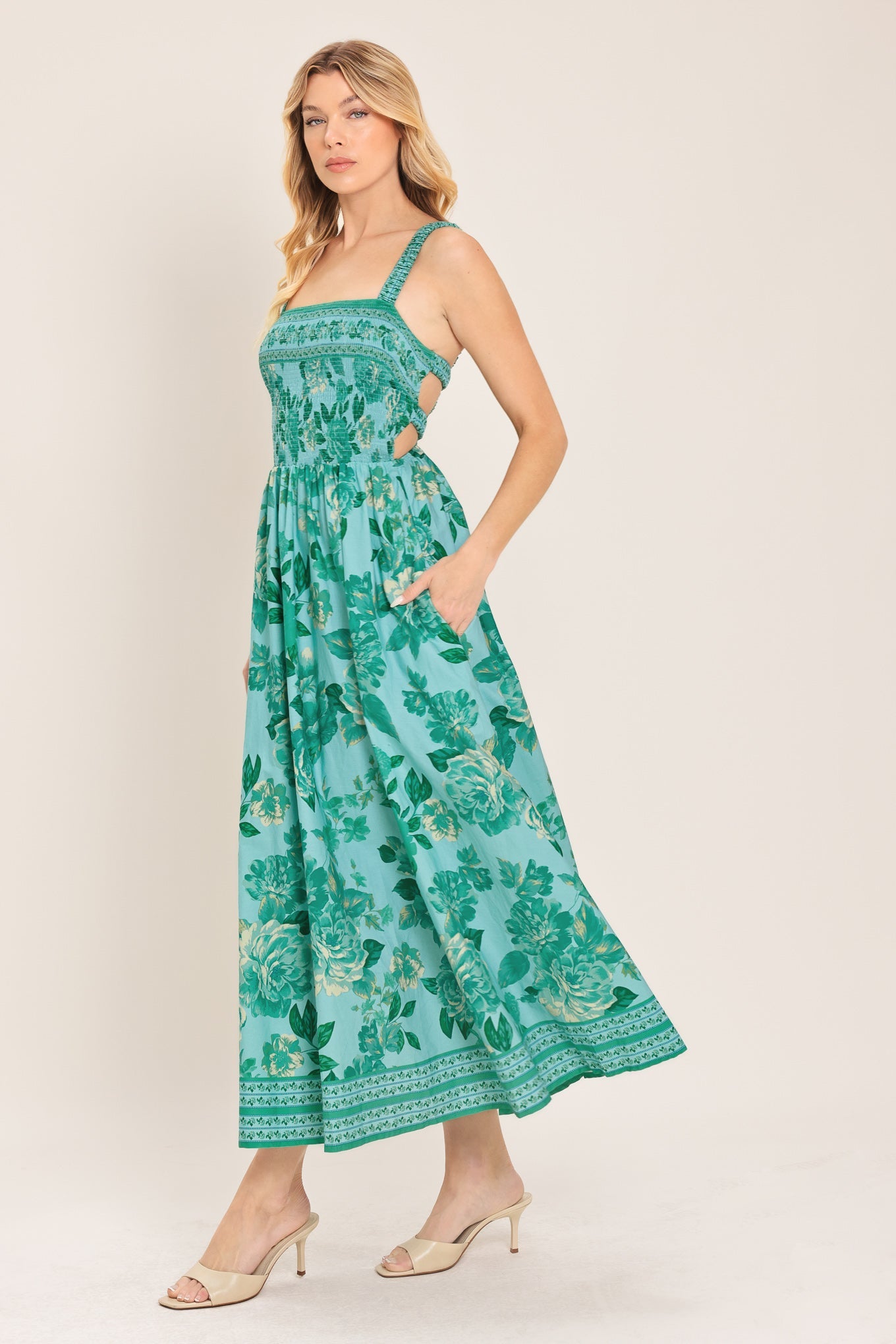 Woman wearing a green floral dress on a white background