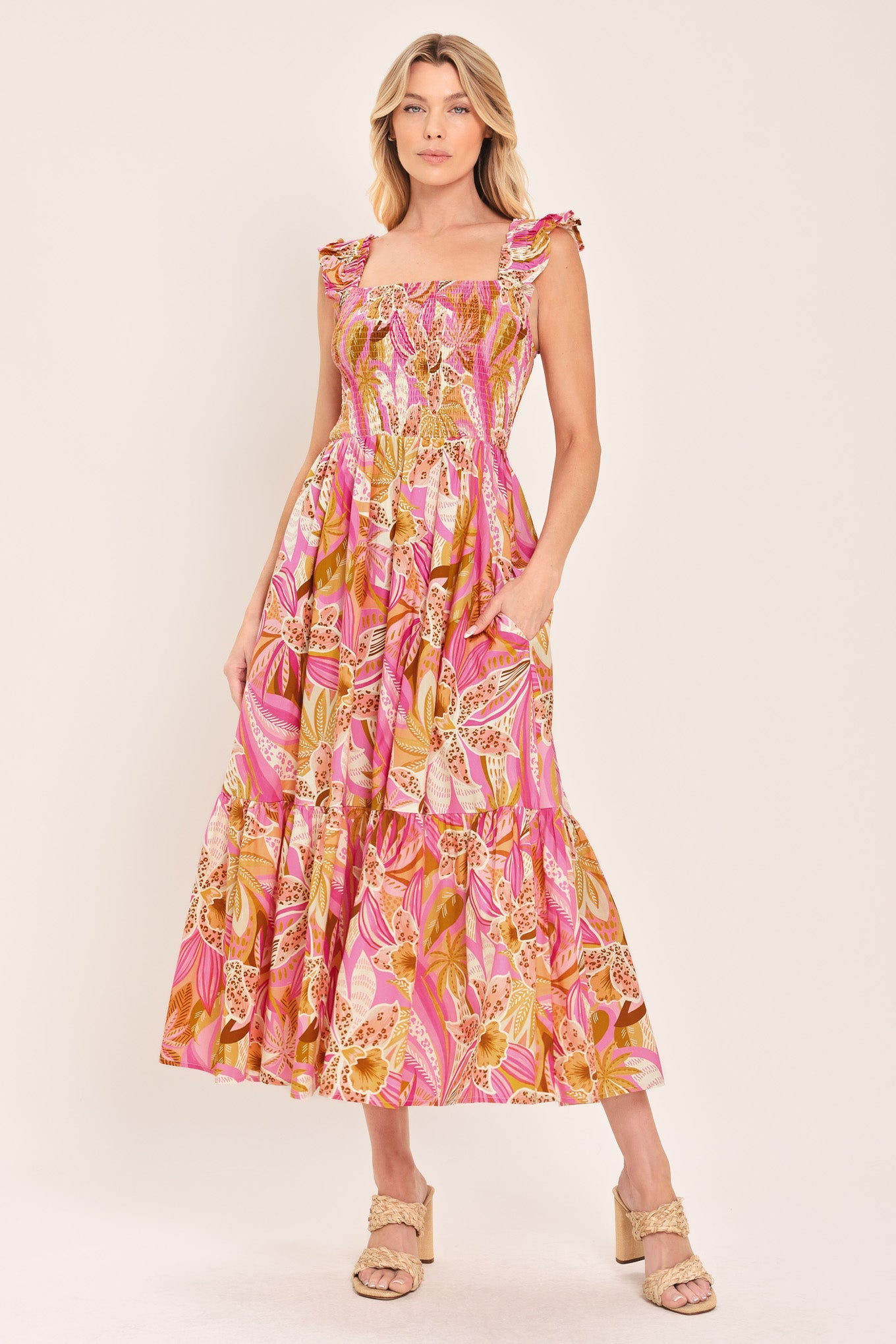 Woman wearing a pink and yellow floral dress on a white background