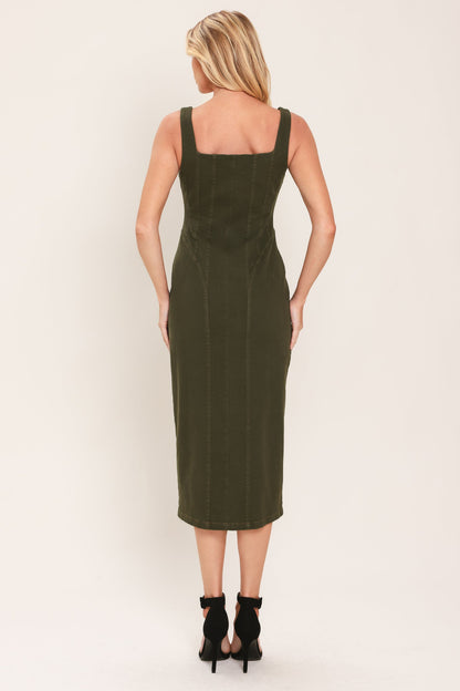 A woman viewed from the back wearing an olive green sleeveless midi dress with a square neckline and black ankle-strap heels, set against a plain off-white studio background.