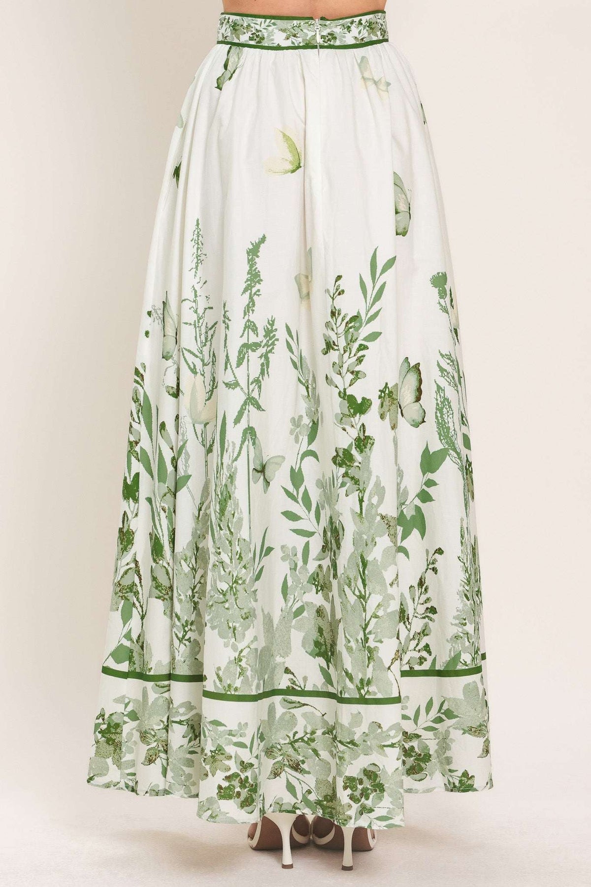 Long white skirt with green floral pattern on a plain background