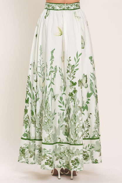 Long white skirt with green floral pattern on a plain background