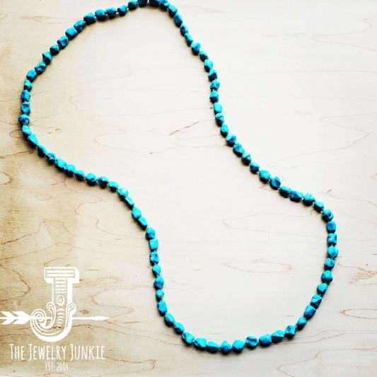 Turquoise beaded necklace on a light wooden surface with 'The Jewelry Junkie' logo.