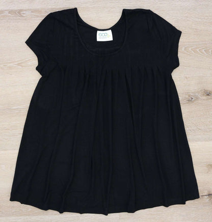 Black short-sleeve pleated fabric top with an ECO DESIGNZ label, laid flat on a light wood surface.