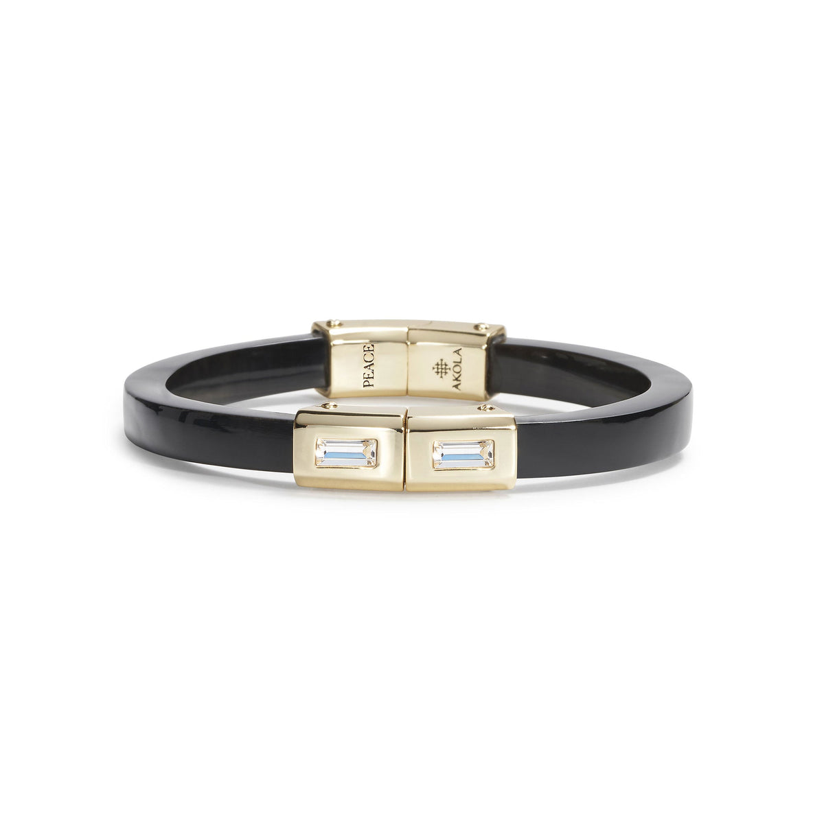 A black bangle bracelet with gold-toned hardware, featuring rectangular bezel-set light blue crystals on the front clasp, shown against a plain white background.