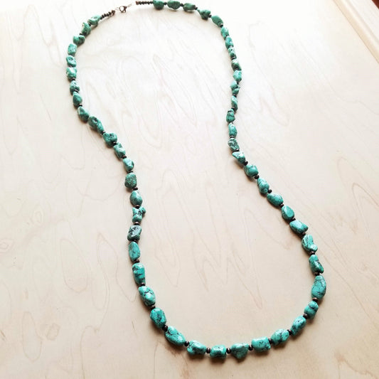 Turquoise beaded necklace on a light wooden surface