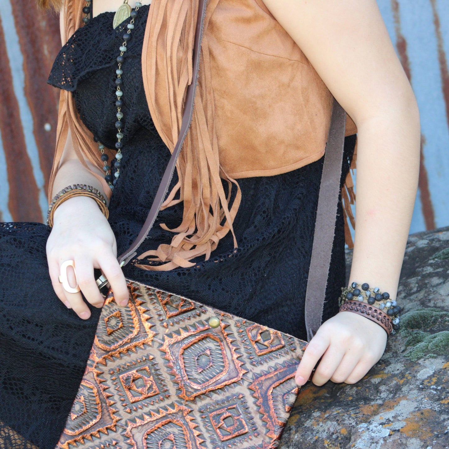 Person holding a patterned bag with a rustic background