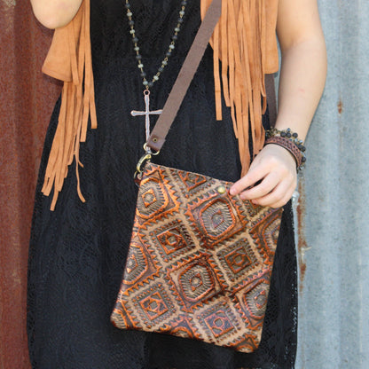 Person holding a patterned bag with fringe details