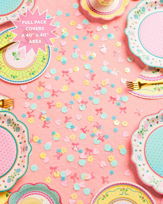 Floral paper plates, gold forks, and pastel confetti arranged on a pink surface with a Full Pack Covers A 40" x 40" Area s...