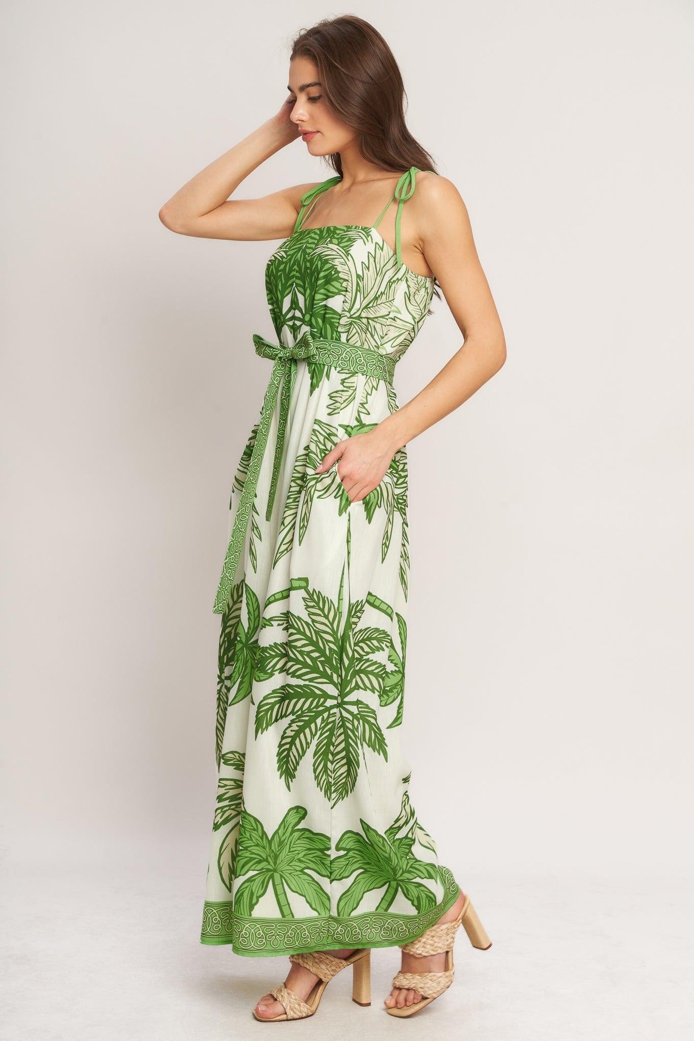 Woman wearing a green and white floral dress against a plain background