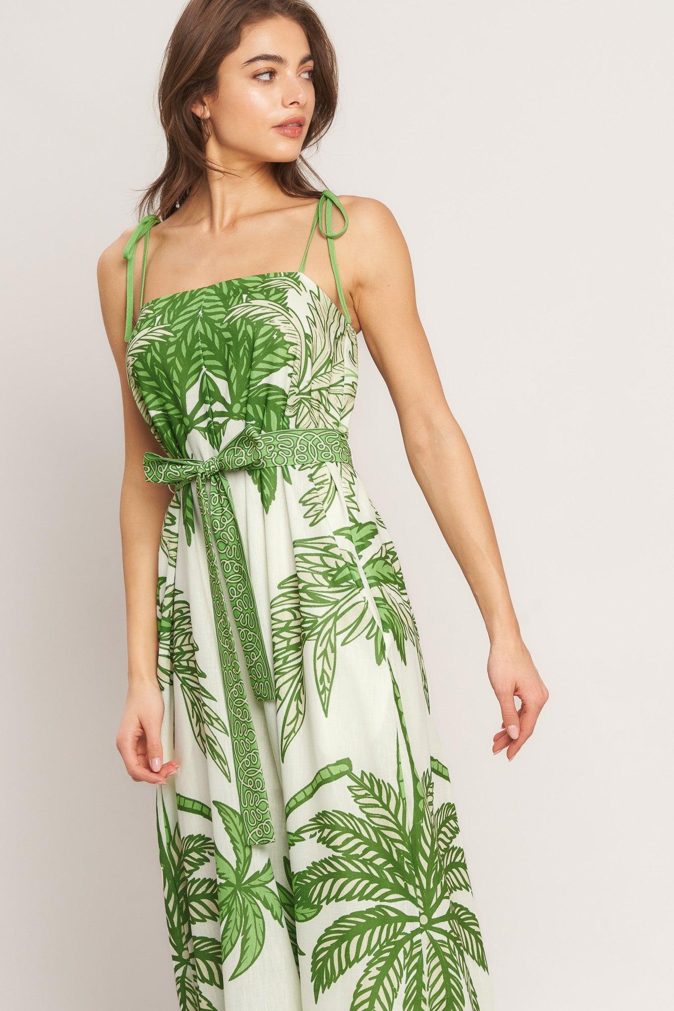 Woman wearing a green and white floral dress on a plain background