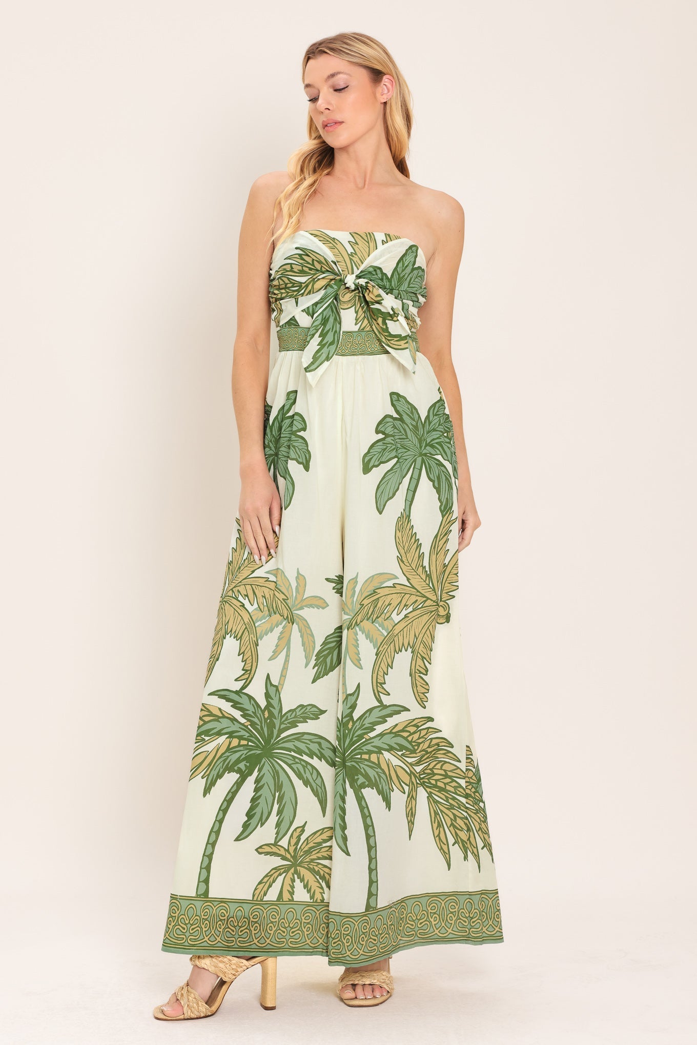 Woman wearing a tropical palm leaf patterned dress on a white background