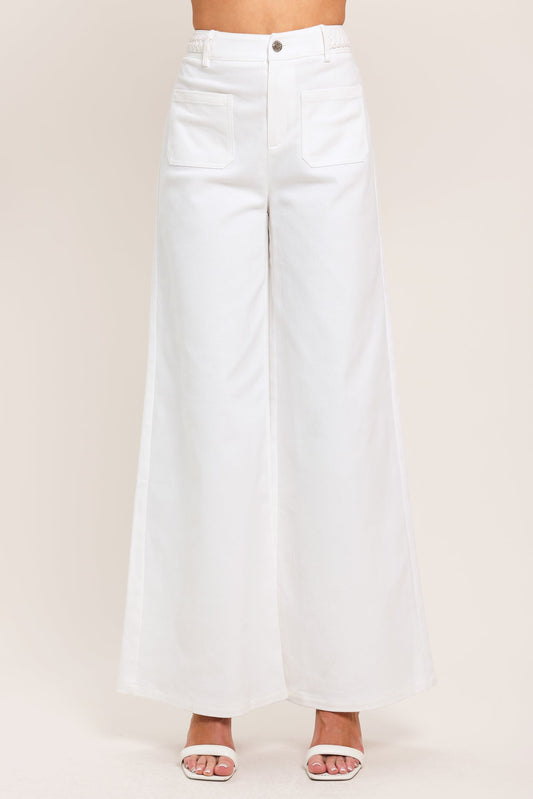 White wide-leg jeans on a plain background
