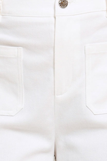 Close-up of white pants with a button and pocket details.