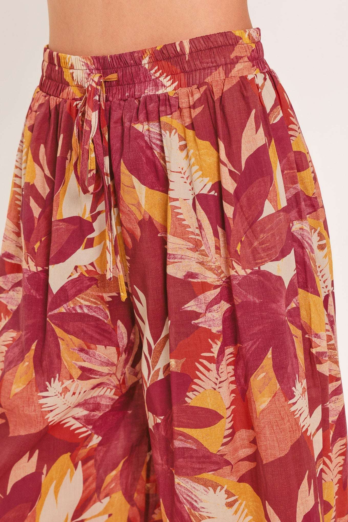 Tropical leaf patterned pants on a plain background