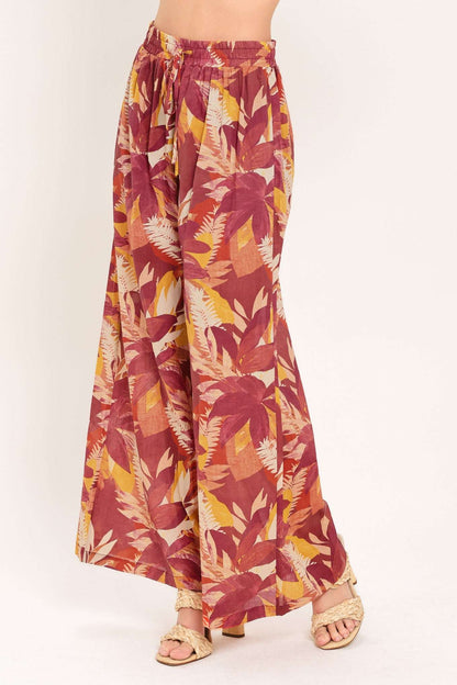Tropical leaf patterned pants on a white background