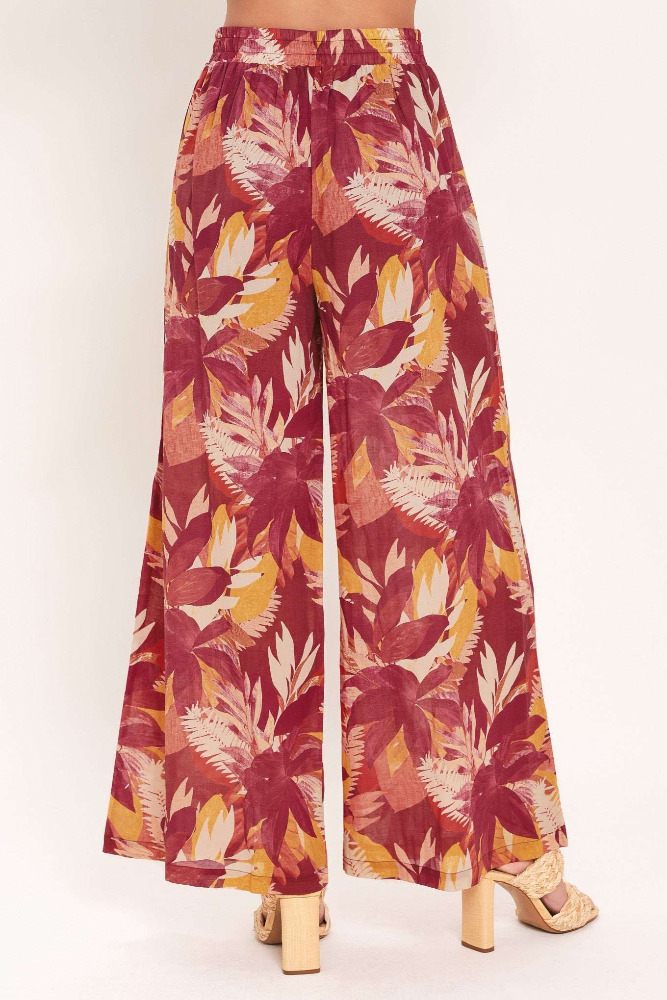 Tropical leaf patterned pants on a white background