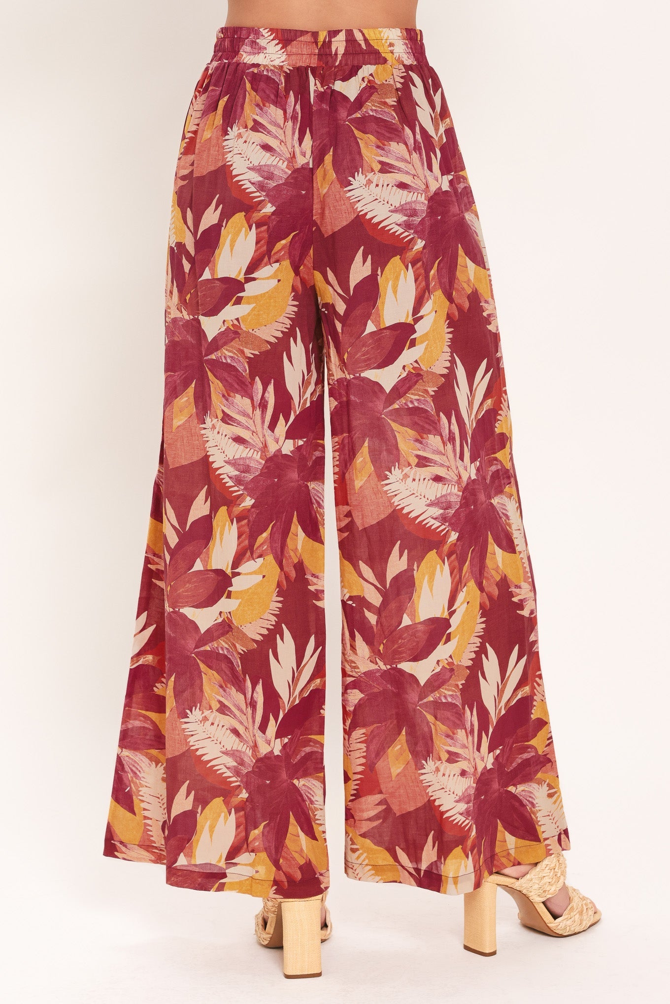 Tropical leaf patterned pants on a white background