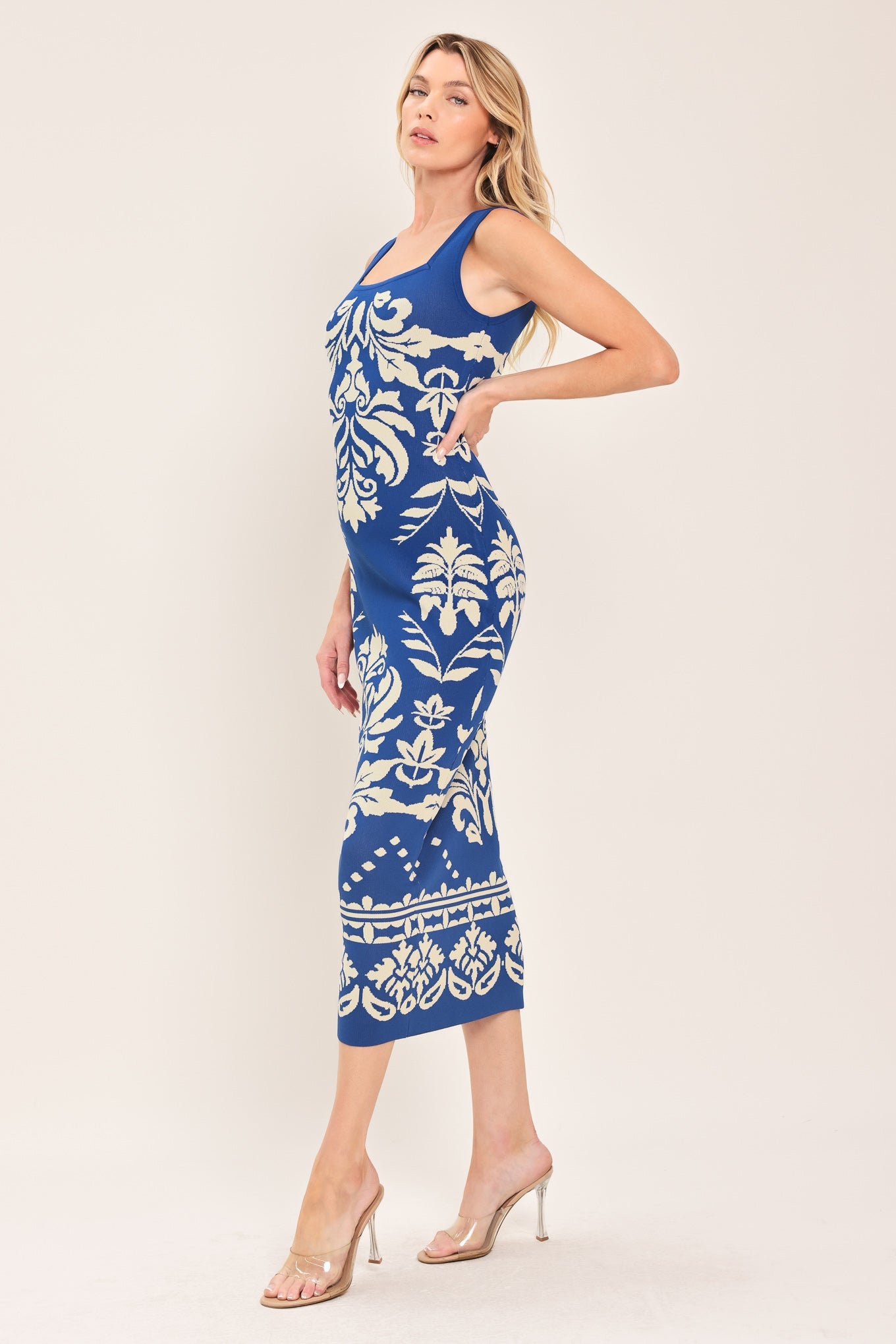 Blue and white floral jacquard midi dress worn by a model standing against a neutral background.