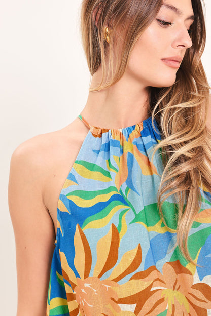 Woman wearing a colorful floral dress with a plain background