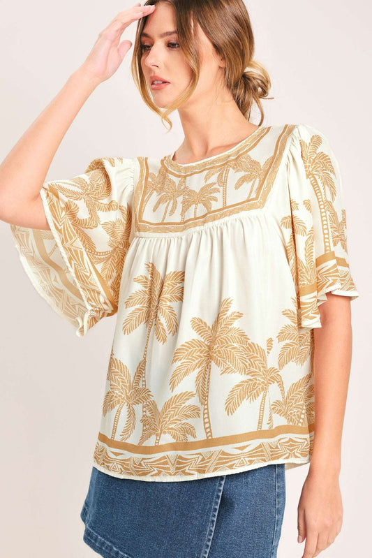 Cream fabric top with tan palm tree print, flutter sleeves, and a square neckline border worn with blue denim.