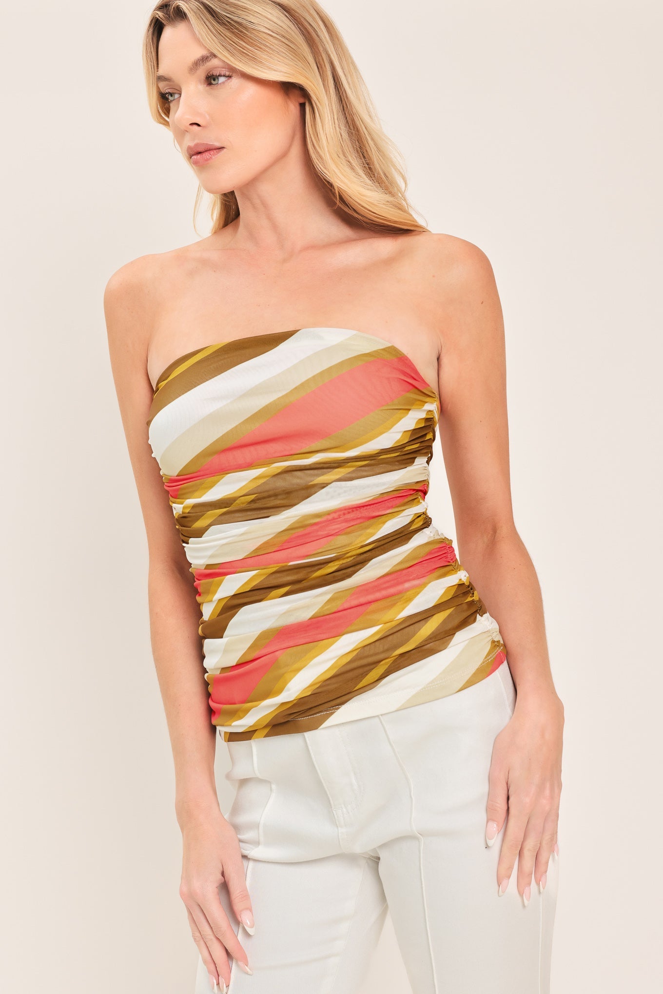 Woman wearing a strapless top with colorful geometric pattern on a plain background